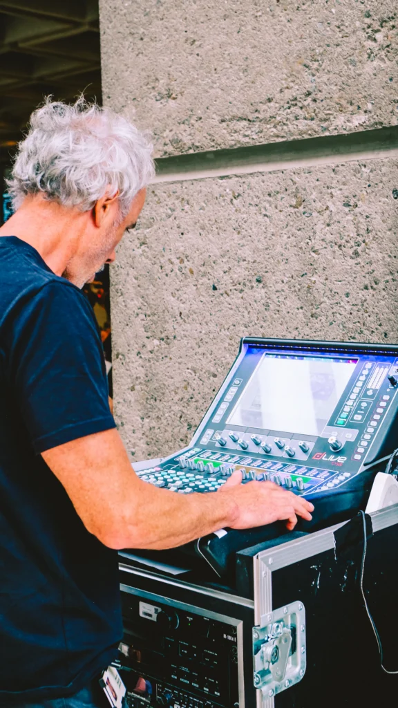 Technicus bedient een digitale mengtafel in een flightcase